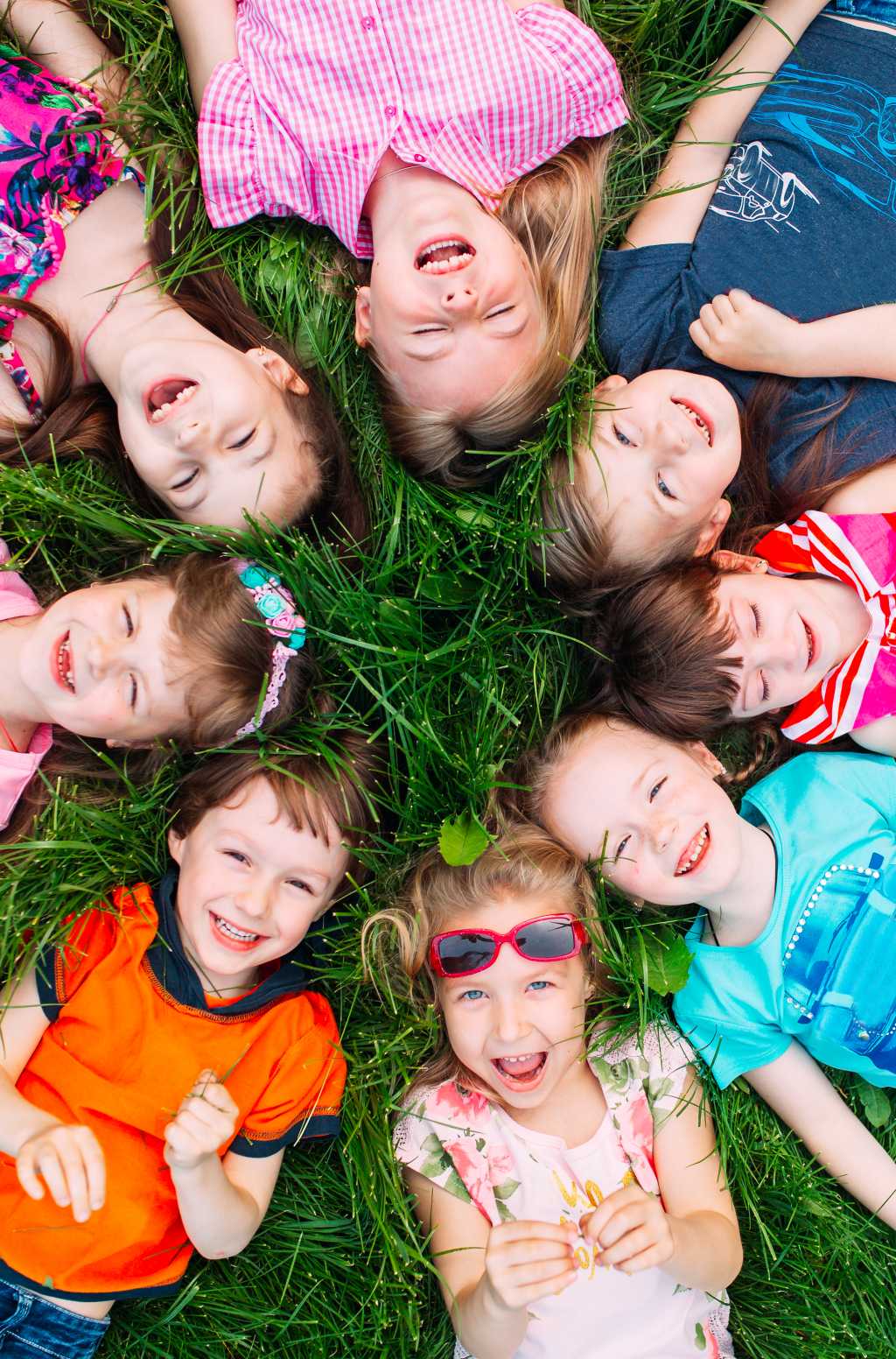 A group of children lying on the green grass in the Park. The in